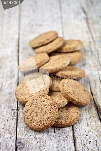 Image of Fresh baked oat cookies on rustic wooden table.