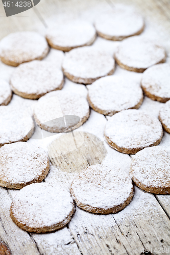 Image of Fresh baked oat cookies with sugar powder on rustic wooden table