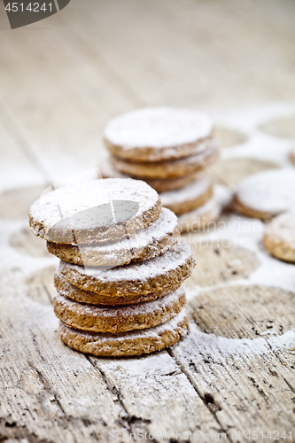 Image of Fresh oat cookies with sugar powder on rustic wooden table.