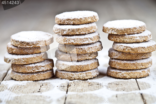 Image of Fresh oat cookies with sugar powder on rustic wooden table.