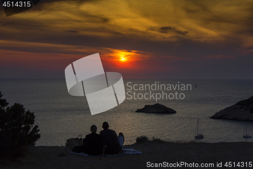Image of Young couple looking at the sea at sunset