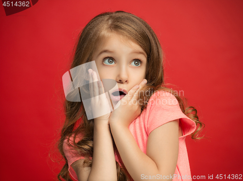 Image of Beautiful teen girl looking suprised isolated on red