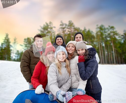 Image of friends with snow tubes taking selfie in winter