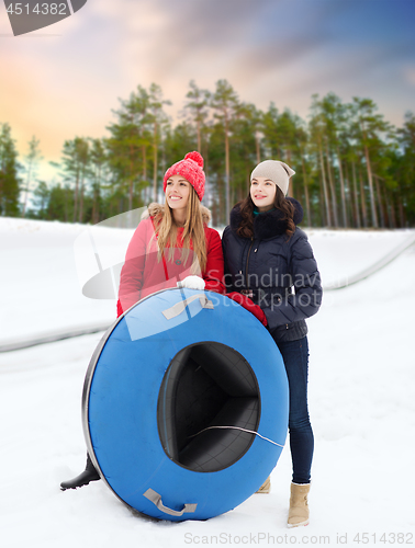 Image of happy teenage girls with snow tubes in winter