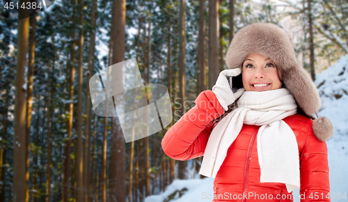 Image of woman calling on smartphone over winter forest