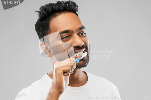 Image of indian man with toothbrush cleaning teeth