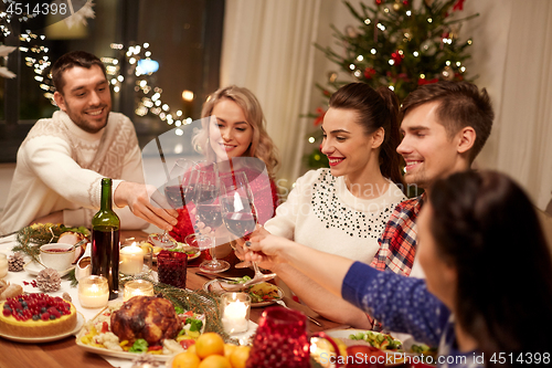 Image of friends celebrating christmas and drinking wine