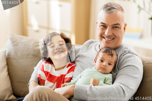 Image of happy father with preteen and baby son at home