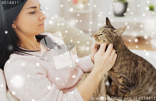 Image of close up of woman with tabby cat in bed at home