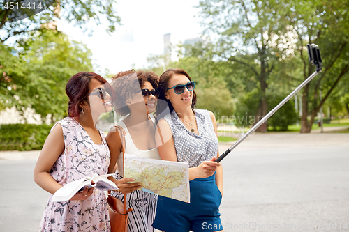 Image of women with city guide and map taking selfie