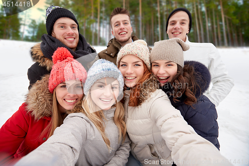 Image of group of friends taking selfie outdoors in winter