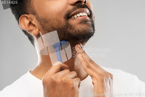 Image of close up of man shaving beard with razor blade