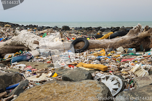 Image of Spilled garbage on the beach near the big city. Empty used dirty plastic bottles and other garbage. Environmental pollution. Ecological problem.