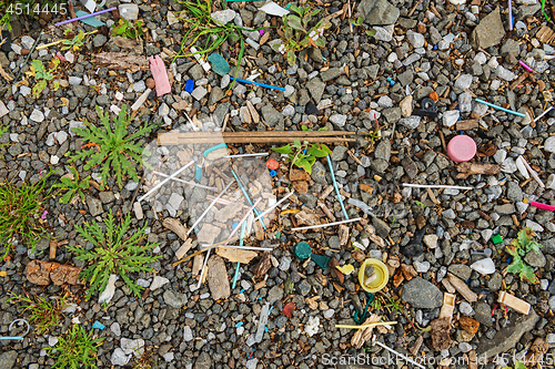 Image of Garbage on the beach near the big city. Used dirty plastic sticks and other garbage. Environmental pollution.