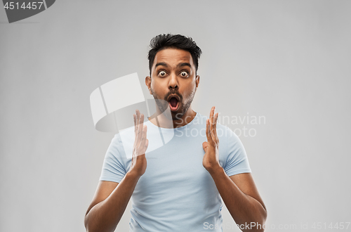 Image of scared man in t-shirt over grey background