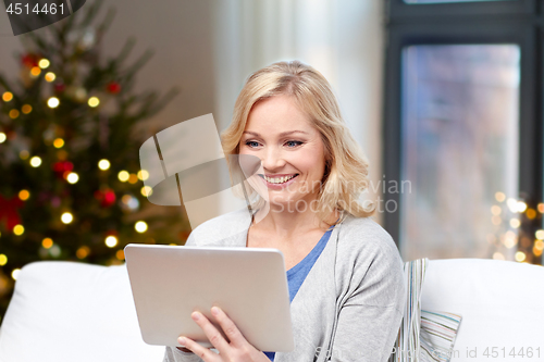 Image of woman with tablet pc at home on christmas