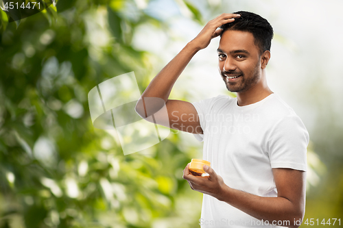 Image of indian man applying hair wax or styling gel