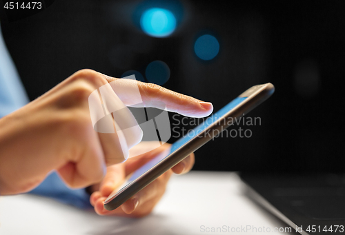 Image of close up of hands with smartphone at night office