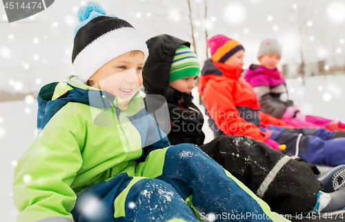 Image of happy little kids riding sleds in winter