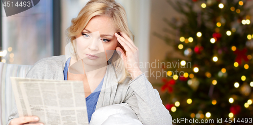 Image of woman reading newspaper on christmas at home