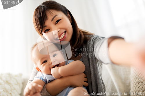 Image of happy mother with little baby son taking selfie