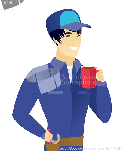 Image of Young asian mechanic holding cup of coffee.