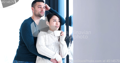 Image of multiethnic couple relaxing at modern home indoors
