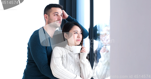 Image of multiethnic couple relaxing at modern home indoors