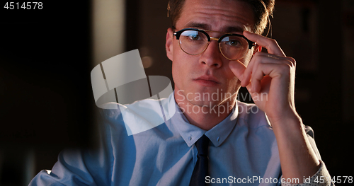 Image of man working on computer in dark office