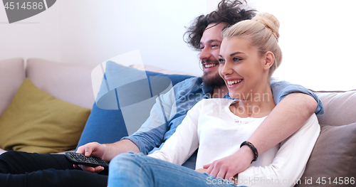 Image of Young couple on the sofa watching television