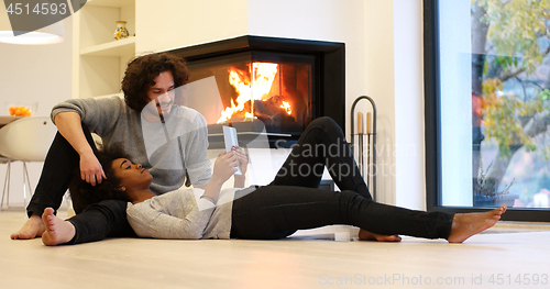 Image of Young Couple using digital tablet on the floor