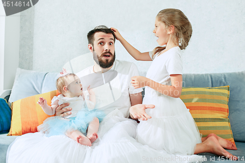 Image of The happy father and his baby daughters at home