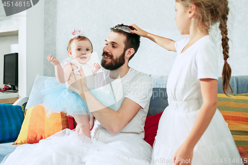 Image of The happy father and his baby daughters at home
