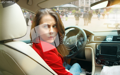 Image of Driving around city. Young attractive woman driving a car