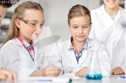 Image of kids with test tube studying chemistry at school