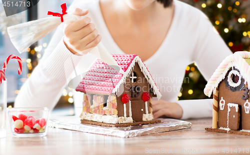 Image of woman making gingerbread houses on christmas