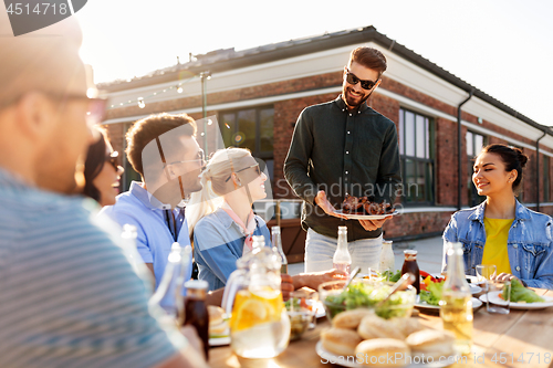 Image of friends at barbecue party on rooftop in summer