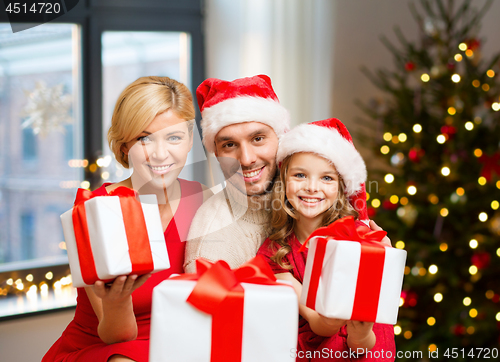 Image of happy family with christmas gifts at home