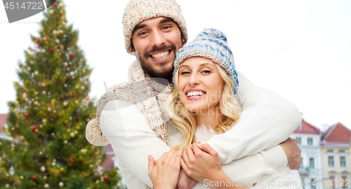 Image of happy couple hugging over christmas tree