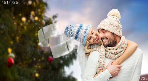 Image of happy couple hugging over christmas tree