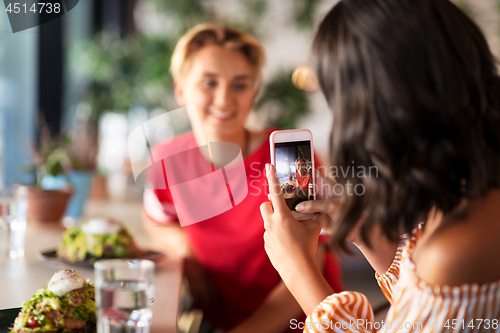 Image of women having lunch and photographing at cafe