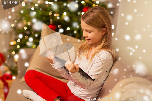 Image of smiling girl with tablet pc at christmas home