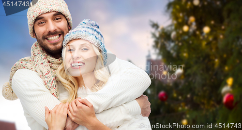 Image of happy couple hugging over christmas tree