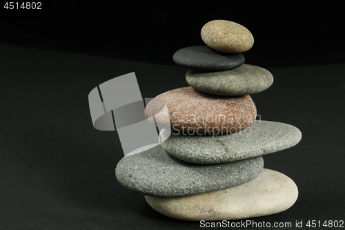 Image of Seven pebbles pyramid over dark