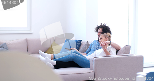 Image of Young couple on the sofa watching television
