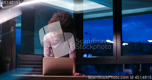 Image of black businesswoman using a laptop in night startup office