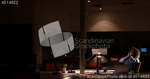 Image of man working on computer in dark office