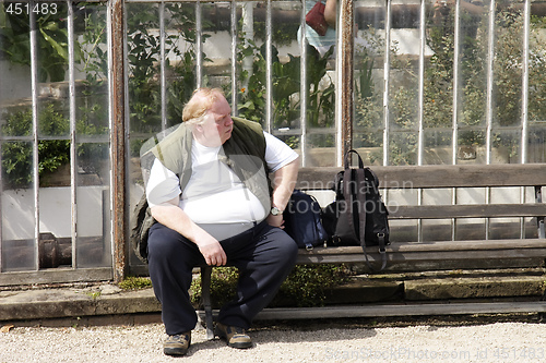 Image of large man sitting on a bench