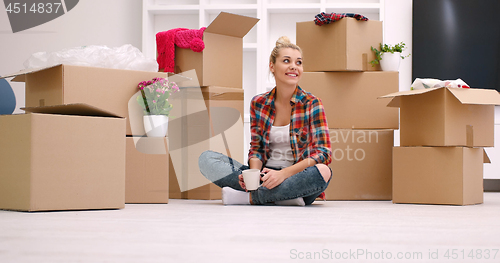 Image of woman with many cardboard boxes sitting on floor