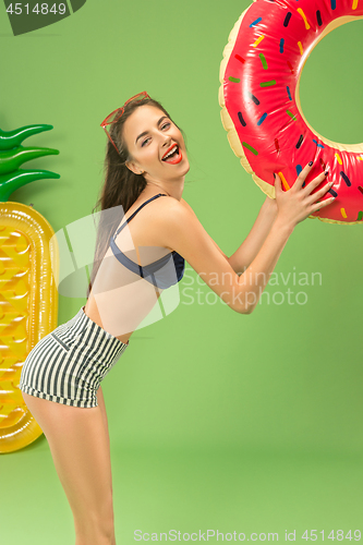 Image of Cute girl in swimsuit posing at studio. Summer portrait caucasian teenager on green background.